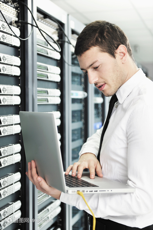 轻的IT工程师与商务人员 现代铝制笔记本电脑与网络服务器机房的融合